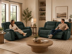 Man and a woman sit on dark teal reclining loveseats